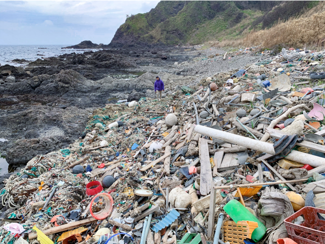 藤元氏と海岸の大量のプラスチックゴミ
